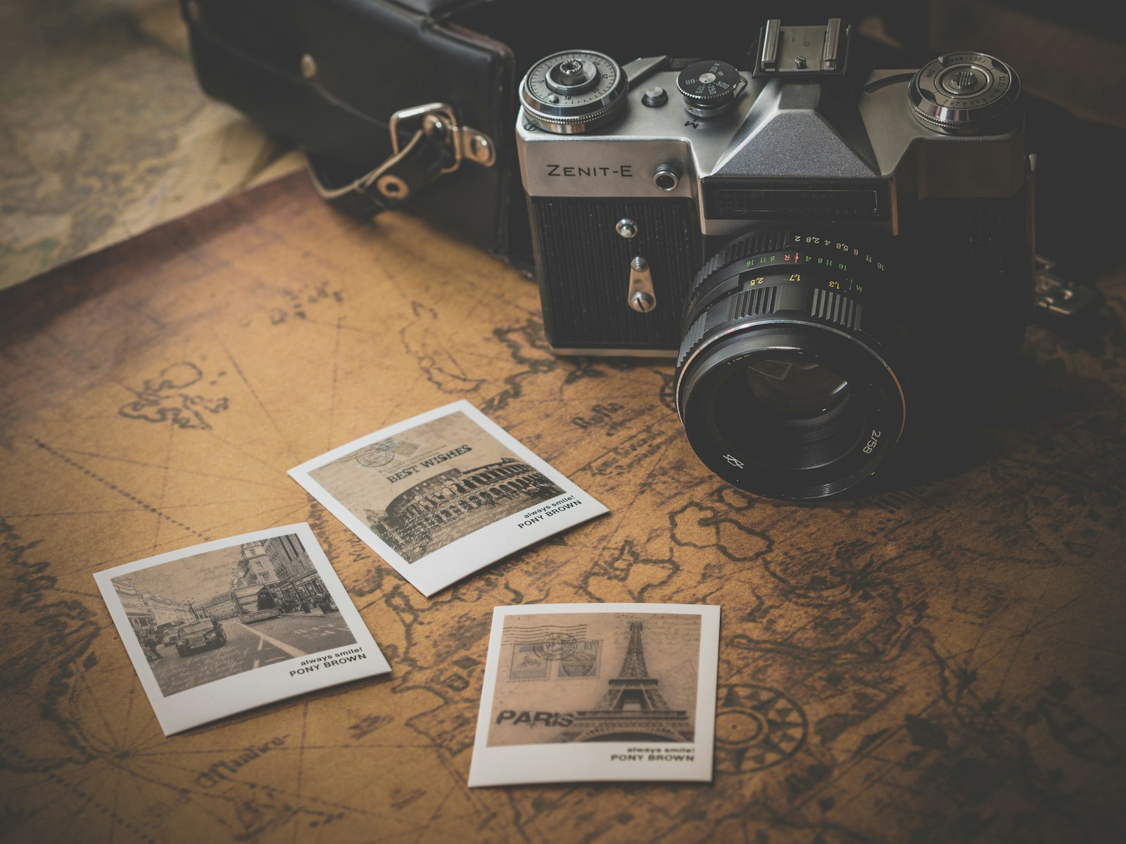 Harita üzerinde duran fotoğraf makinesi ve basılı fotoğraflar